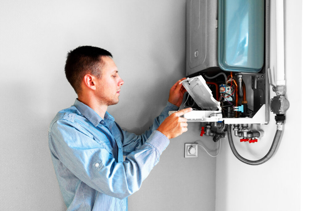 plumber attaches trying fix problem with residential heating equipment