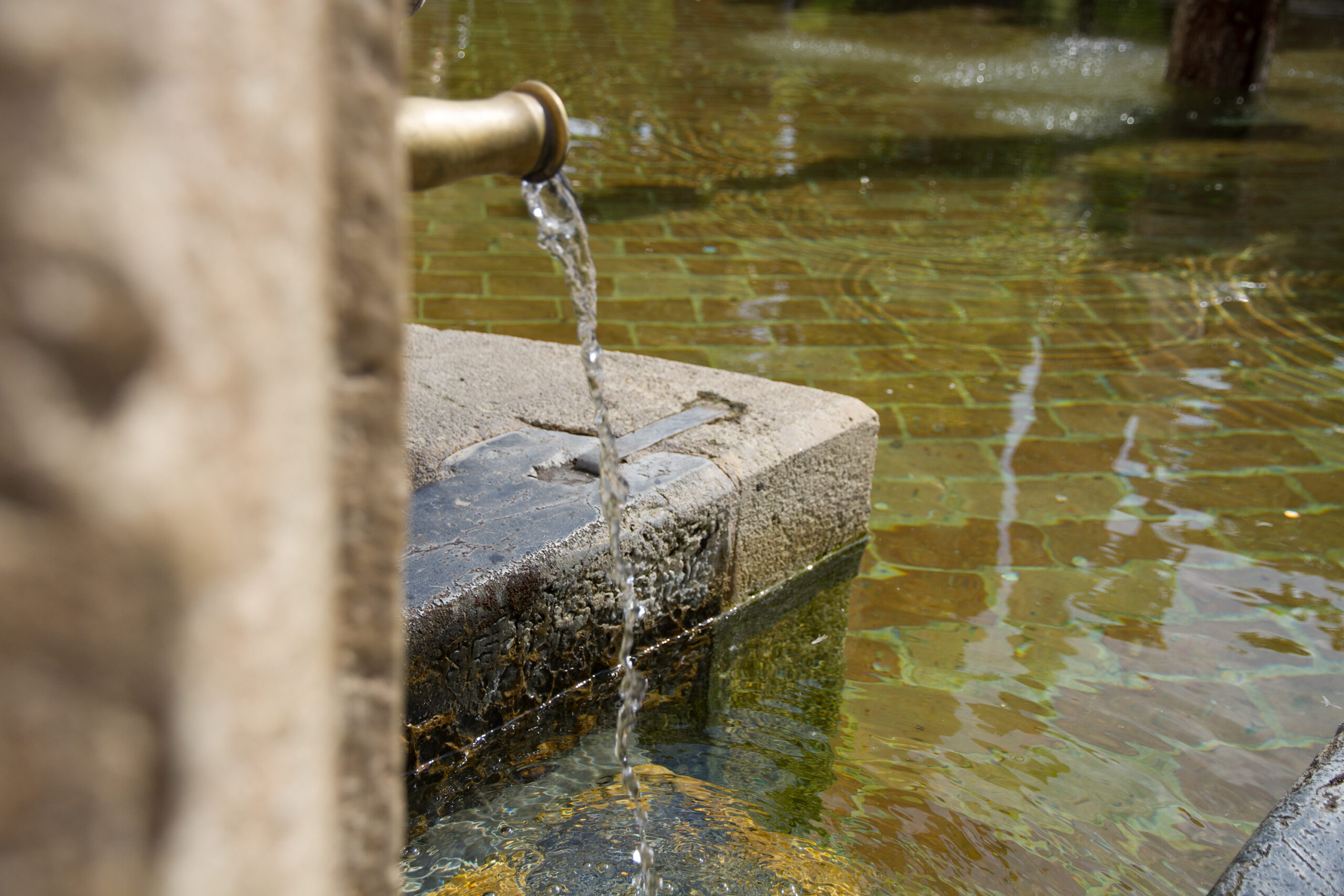 water running into old fountain from scaled